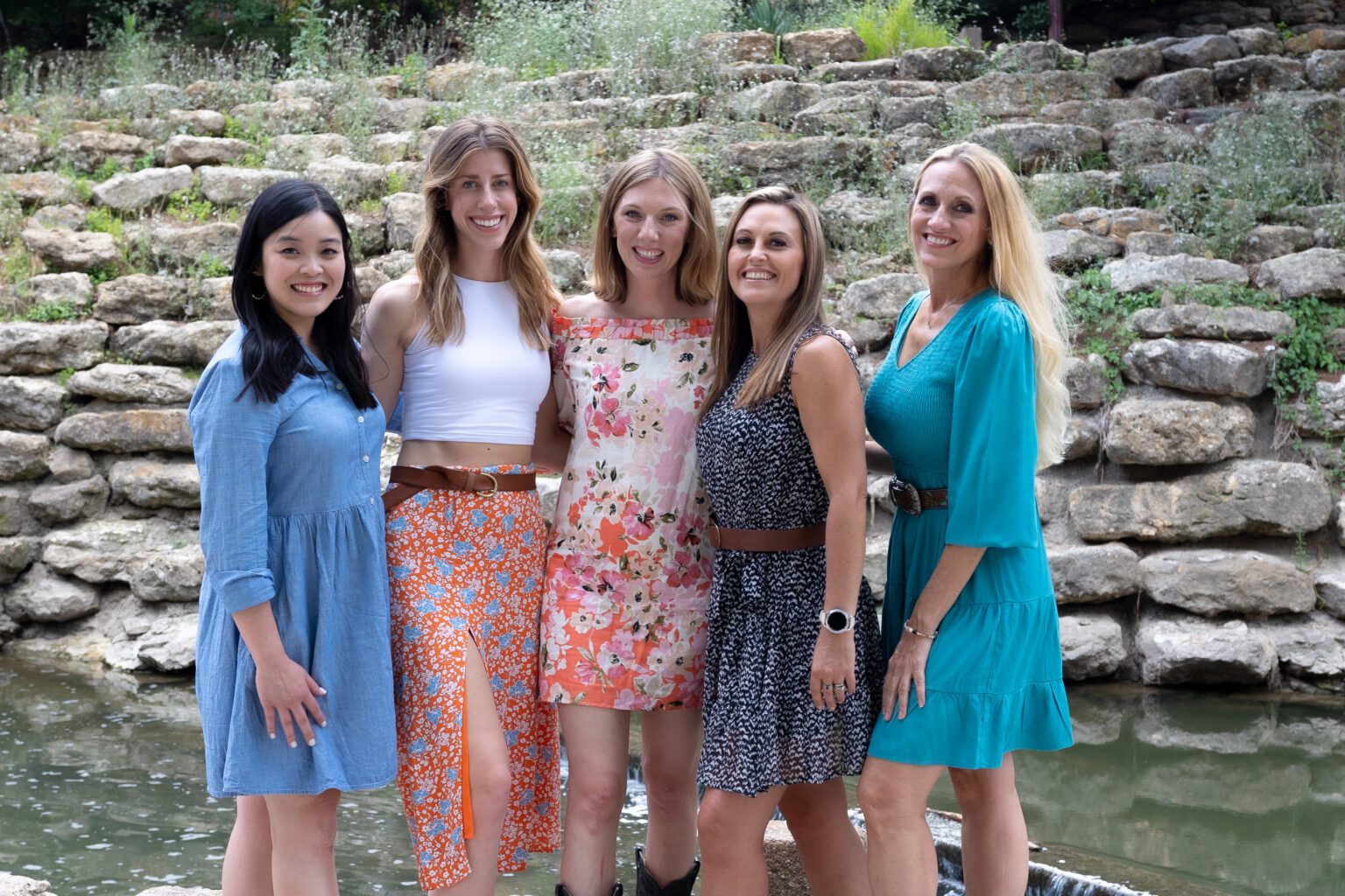 The Flex team posing in front a pond and stone terrace